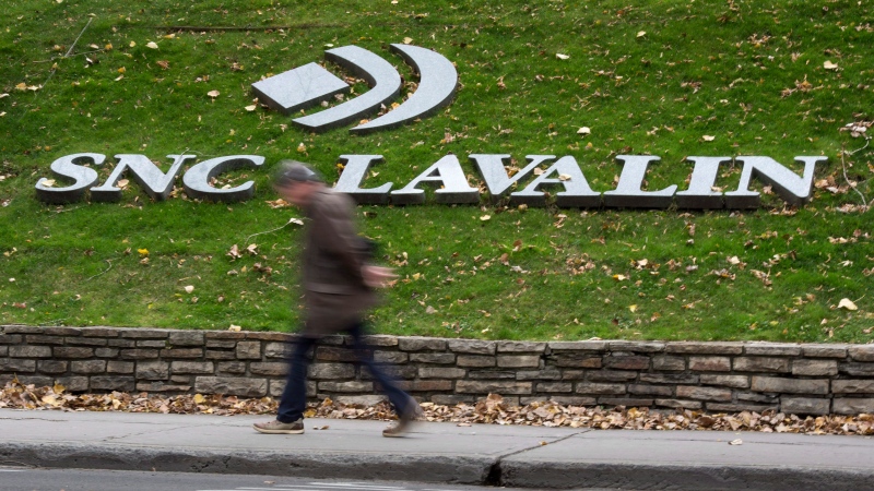 A man walks past the headquarters of SNC-Lavalin in Montreal on Nov. 6, 2014. (THE CANADIAN PRESS/Paul Chiasson)