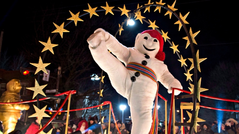 Bonhomme Carnaval raises his leg in a traditional step at the Quebec Winter Carnival night parade on Saturday, February 16, 2013 in Quebec City. THE CANADIAN PRESS/Jacques Boissinot