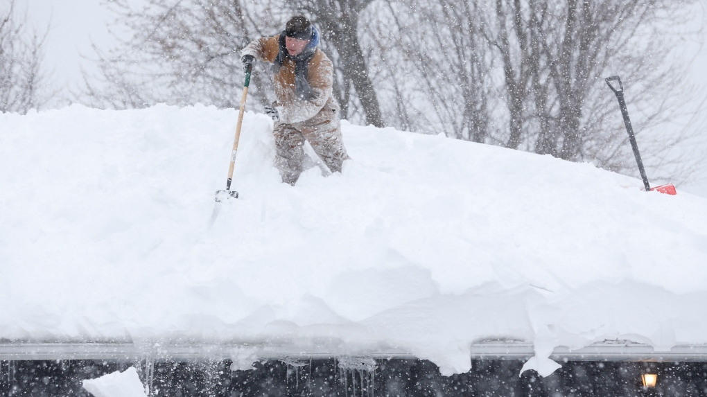 Snow is removed from a roof (AP Photo/Mike Groll)