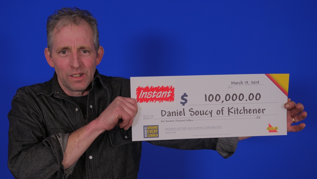 Daniel Soucy holding a $100,000 cheque.