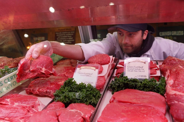 Butcher Robert Bustos picks out an organic beef steak at a Whole Foods in Lakewood, Colo., on Thursday, May 21, 2009. (AP / Ed Andrieski)