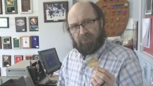 Gary Lamb holds a medal in his Yorkton shop. (Nathaniel Dove/CTV Yorkton)