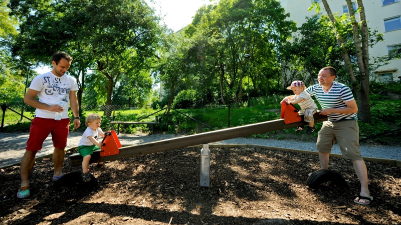 Men and their children play on a seesaw in Stockholm, Sweden in a Wednesday, June 29, 2011 photo. THE CANADIAN PRESS/ AP/Niklas Larsson
