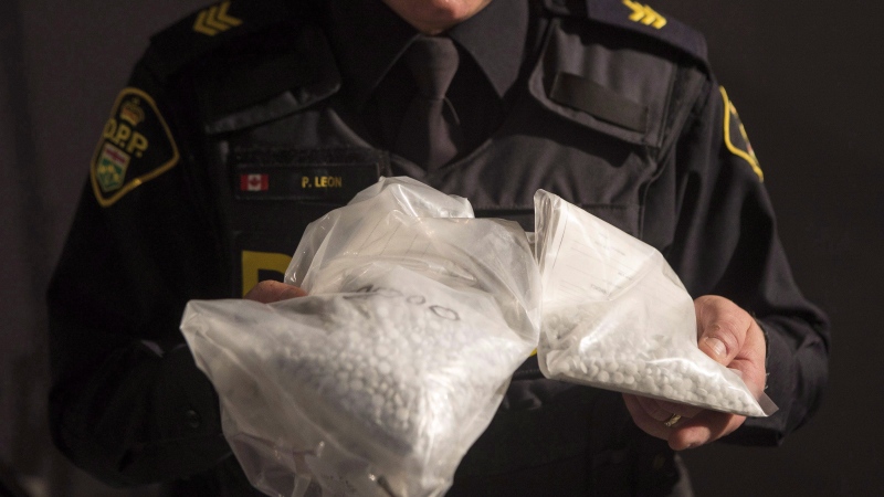 An OPP officer displays bags containing fentanyl as Ontario Provincial Police host a news conference in Vaughan, Ont., on February 23, 2017. (THE CANADIAN PRESS/Chris Young)