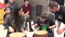 High school athlete Chloe Shum plays the bongos with a youth from the Thames Valley Children’s Centre in London, Ont. on Monday, April  1, 2019. (Brent Lale / CTV London)