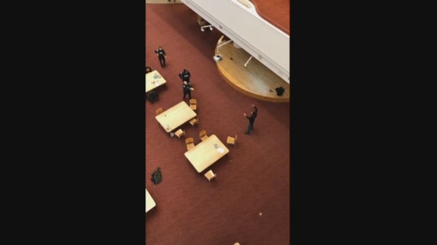 Toronto police confront a man allegedly holding a knife inside the Toronto Reference Library on April 1, 2019.