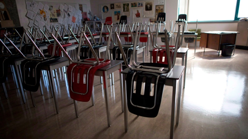 A vacant teachers desk is pictured at the front of a empty classroom is pictured at McGee Secondary school in Vancouver on Sept. 5, 2014.  THE CANADIAN PRESS/Jonathan Hayward