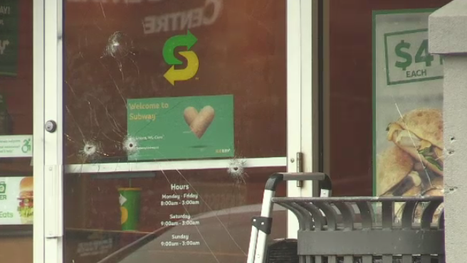 Bullet holes can be seen in the window of a Subway at the University Commons plaza. 