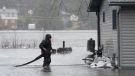 A resident works on his pump as flood waters surround his home on Friday, April 26, 2019 in Ottawa. THE CANADIAN PRESS/Adrian Wyld