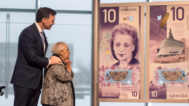 Wanda Robson, second from left, sister of Viola Desmond, admires the new $10 bank note featuring Desmond with Finance Minister Bill Morneau during a press conference in Halifax on Thursday, March 8, 2018. (THE CANADIAN PRESS / Darren Calabrese)