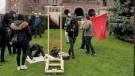 A mock guillotine is seen at a protest held outside of Queen's Park. 