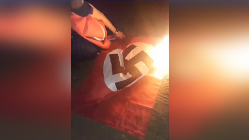 A burning Nazi flag that was hung at a residence in Kelliher, Sask. (Caleb Pelletier)