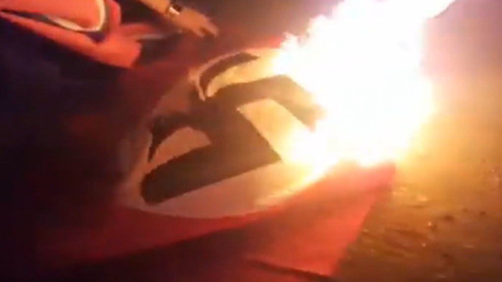 Man rips down, burns Nazi flag flying on house