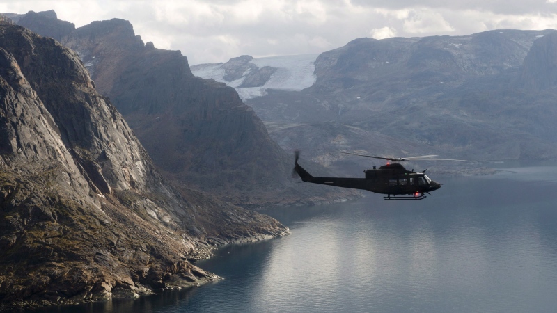 A Canadian military Griffon helicopter flies along the shoreline of Baffin Island on Tuesday August 26, 2014. (THE CANADIAN PRESS/Adrian Wyld)