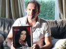Former child star Mark Lester, who is godfather to pop star Michael Jackson's three children, poses with a photo of the star at his home in Cheltenham, England, on Monday June 29, 2009. (AP / Simon Dawson)