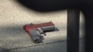 Police were seen inspecting what appeared to be a handgun covered in red dye near the steps of the bank at Tillicum Mall. (CTV Vancouver Island)