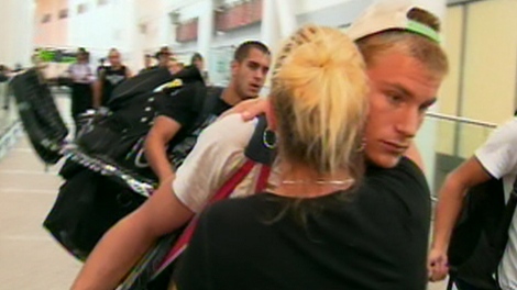 One of the hockey players receives a hug from a relative after arriving at Pearson Airport on Tuesday, Aug. 11, 2009.