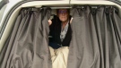 Diane Claveau draws curtains in her van.