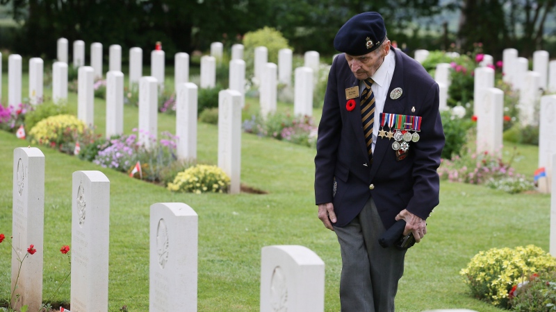 Canadian World War II veteran Bill Tymchuk, looks at headstones after attending a ceremony at the Beny-sur-Mer Canadian War Cemetery in Reviers, Normandy, France, Wednesday, June 5, 2019. (AP Photo/David Vincent)
