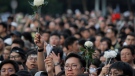 Protesters hold up flowers to pay respect for a man who fell to his death on Saturday after hanging a protest banner against an extradition bill in Hong Kong Sunday, June 16, 2019. HongKong residents were gathering Sunday for another massive protest over an unpopular extradition bill that has highlighted the territory's apprehension about relations with mainland China. (AP Photo/Kin Cheung)