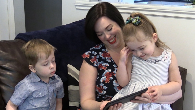 Chelsea Killin, who recently had surgery for Diastasis Recti, reads with her twins in London, Ont. on Monday, June 24, 2019. (Celine Moreau / CTV London)