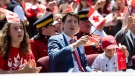 Prime Minister Justin Trudeau waves a Canadian flag during musician K'naan's performance of "Wavin' Flag" at the Canada Day noon show on Parliament Hill in Ottawa on Monday, July 1, 2019. THE CANADIAN PRESS/Justin Tang