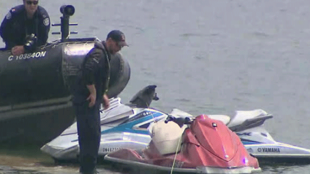 Members of the Toronto Police Marine Unit are shown inspecting two Sea Doos that were involved in a fatal collision in Lake Ontario on Saturday.