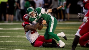 Saskatchewan Roughriders quarterback Cody Fajardo (7) is pulled down by Calgary Stampeders defensive end Chris Casher (96) during first half CFL action in Regina on Saturday, July 6, 2019. THE CANADIAN PRESS/Matt Smith