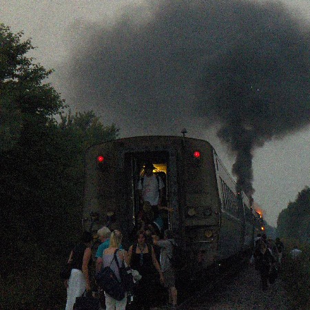 Smoke billows into the air as Via Rail passengers evacuate an Ottawa-bound train, Sunday, Aug. 16, 2009. Viewer photo.