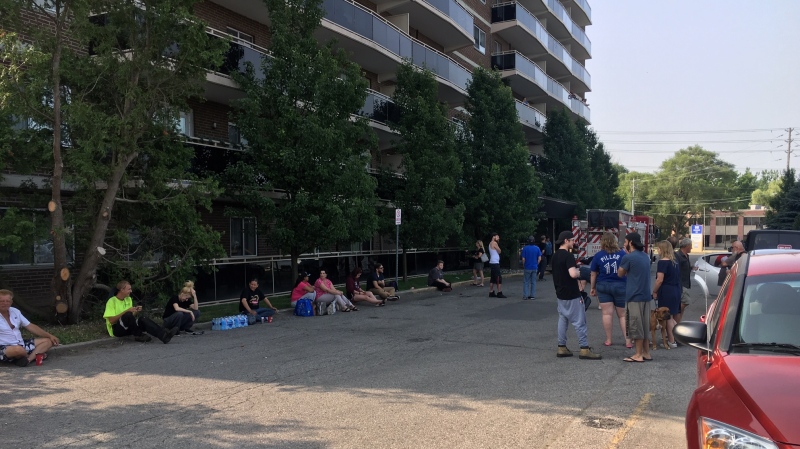 Residents wait outside of 940 Commissioners Road after a burst pipe flooding several floors in London, Ont. on Wednesday, July 10, 2019. (Gerry Dewan / CTV London)
