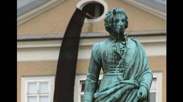 A statue of famed Austrian composer Wolfgang Amadeus Mozart stands in front of a house in Salzburg, Austria on Tuesday, Nov. 14, 2000. (AP / Camay Sungu)