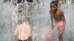 Children play in a water fountain in Antwerp, Belgium, Thursday, July 25, 2019. Belgium experienced a code red, extreme heat warning, on Thursday as temperatures soared during the second heat wave of the summer. (AP Photo/Virginia Mayo)