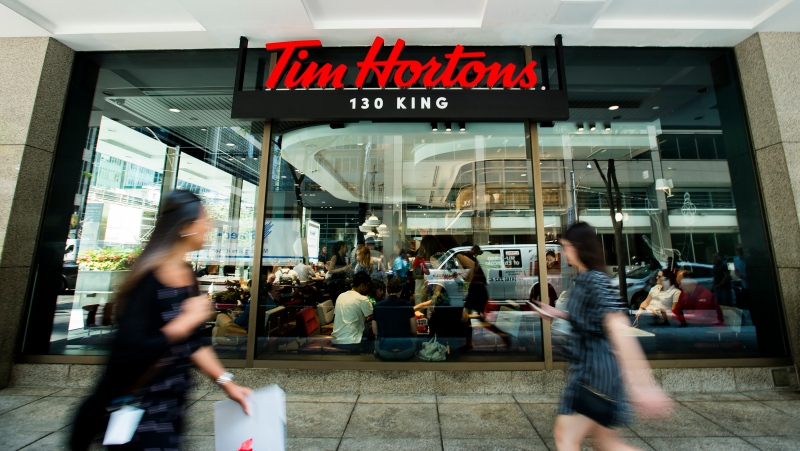 People walk past the newly renovated Tim Hortons in Toronto on Thursday, July 25, 2019. (THE CANADIAN PRESS / Nathan Denette)
