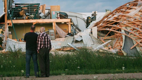Residents look over a destroyed printing facility by damage caused when an apparent tornado touched down on the edge of Durham, Ontario, Thursday, August 20, 2009. (Dave Chidley / THE CANADIAN PRESS)