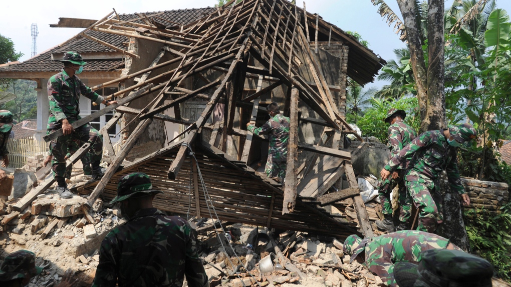 Indonesian soldiers remove debris after earthquake