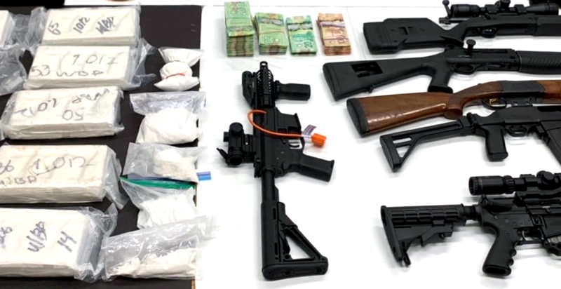 Firearms, cash and drugs seized in a probe conducted by officials in Ontario are seen. (Ontario Provincial Police)