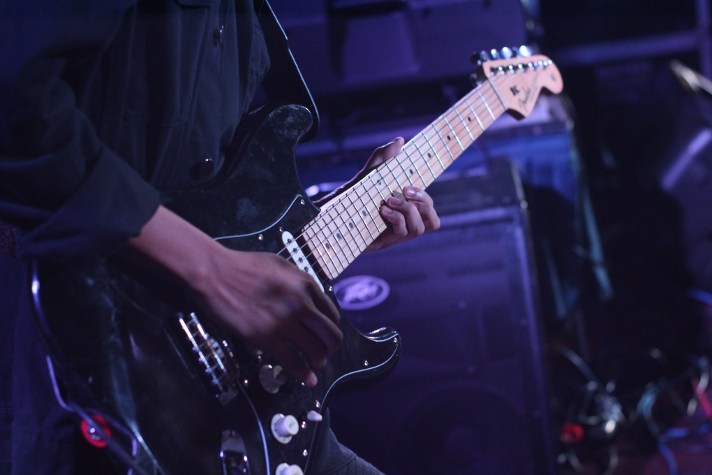 A person playing an electric guitar.