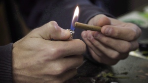 A man lights a marijuana cigarette on April 25, 2017. THE CANADIAN PRESS/Joe Mahoney