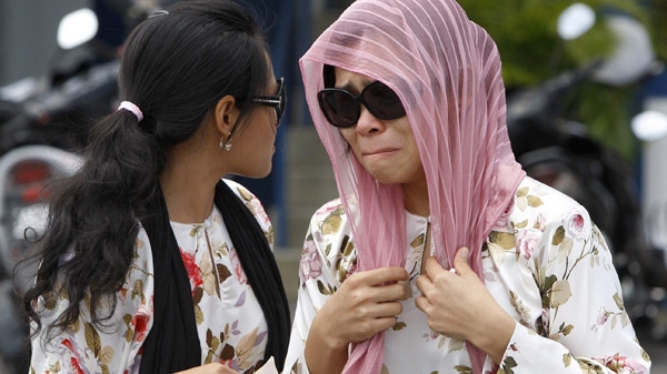 Muslim model Kartika Sari Dewi Shukarno, 32, right, who was to be caned for drinking beer, is comforted by her sister Ratna as she left the Kuala Kangsar police station, Malaysia, Monday, Aug. 24, 2009. (AP / Mark Baker)