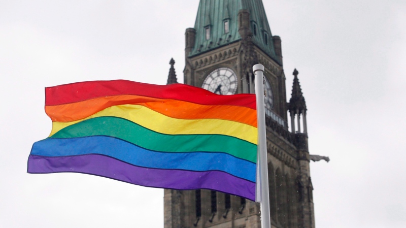 In this file photo, the pride flag flies in front of the Peace Tower on Parliament Hill after a flag raising ceremony in Ottawa on Wednesday, June 20, 2018. (THE CANADIAN PRESS/ Patrick Doyle)