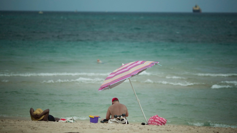 Two sun bathers enjoy the warm sunny breezes on Fort Lauderdale, Fla. beach, Wednesday, April 16, 2014. (AP Photo/J Pat Carter)