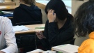 A student is seen using their cellphone inside a classroom in this undated image. (CTV News Toronto) 