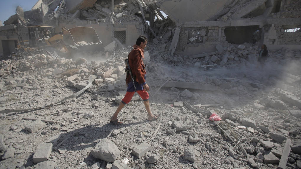 A Yemeni man walks amid the rubble