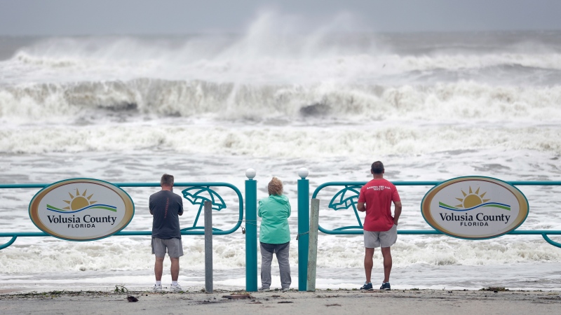 Sightseers watch waves crash on shore as Hurricane Dorian made it's way off the Florida coast Wednesday, Sept. 4, 2019, in Ormond Beach, Fla. (AP Photo/John Raoux)