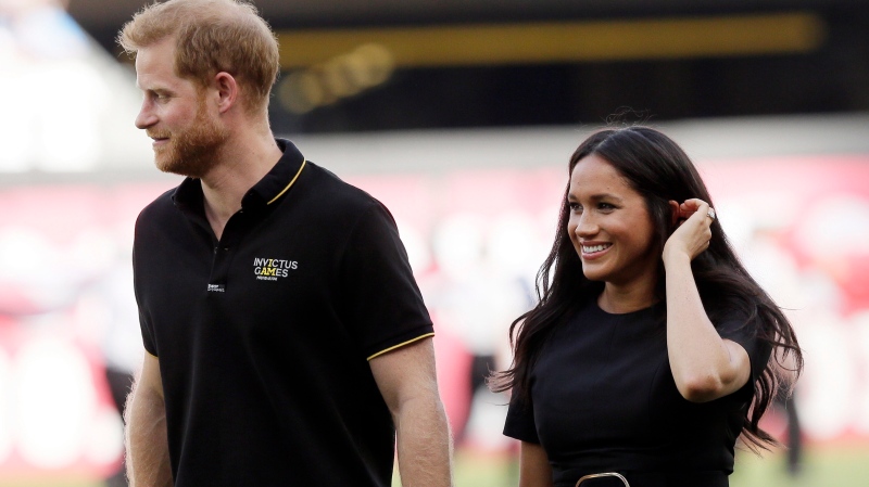 In this Saturday, June 29, 2019 file photo, Britain's Prince Harry, left, and Meghan, Duchess of Sussex, walk off the field before a baseball game in London. (AP Photo/Tim Ireland, file)