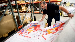 Distribution centre manager Philippe Ouellette arranges a map at the Elections Canada distribution centre in Ottawa on Thursday, Aug 29, 2019. THE CANADIAN PRESS/Sean Kilpatrick