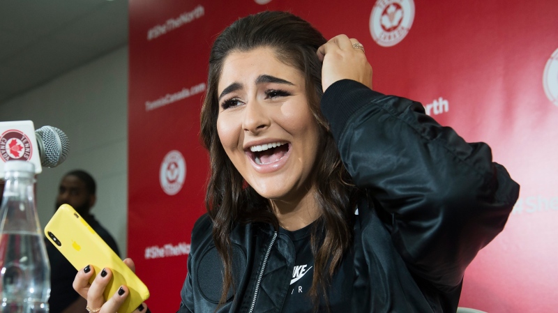 Bianca Andreescu laughs after reading a message from rapper Drake as she speaks to the media after she became the first Canadian player to win a Grand Slam singles title.( THE CANADIAN PRESS/Nathan Denette)