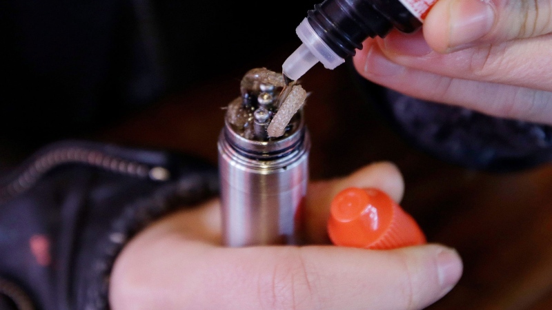 In this Feb. 20, 2014 file photo, a liquid nicotine solution is poured into a vaping device at a store in New York. (AP Photo/Frank Franklin II)