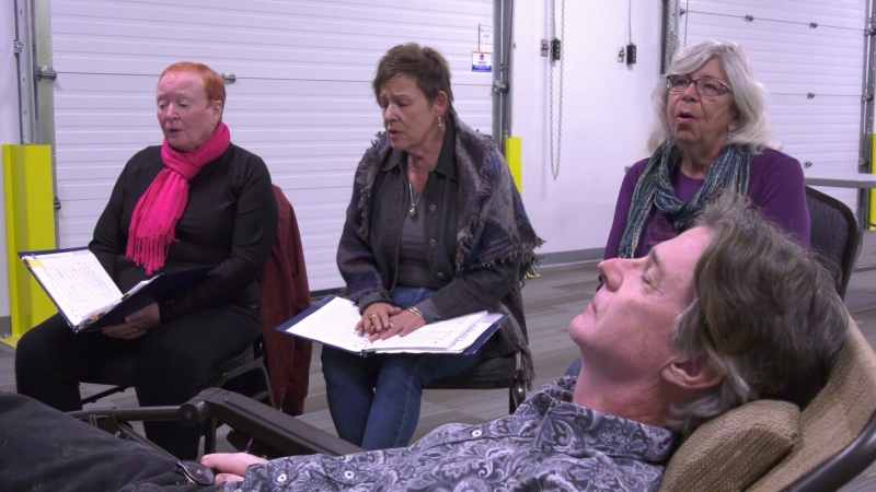 The Edmonton Chapter of Threshold Choir practices while a volunteer lays down to experience what being on the receiving end of the service is like. Sept. 18, 2019. (CTV News Edmonton)