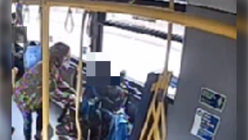 Surveillance video from the bus shows the woman grabbing the man's phone, which he is holding in his lap. (Metro Vancouver Transit Police)